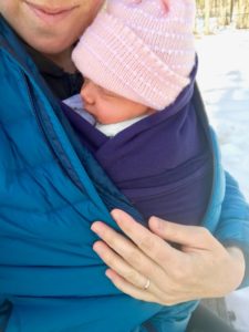 infant in wrap close to mom in winter
