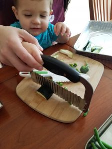 parent and toddler using a children's knife together - getting kids to eat salad