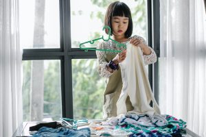 Little girl sorting clothes for spring cleaning