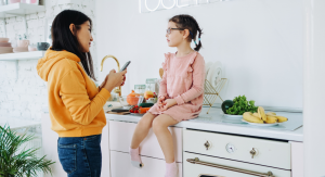 woman talking to young girl as young girl sits on counter - talking to kids about difficult topics