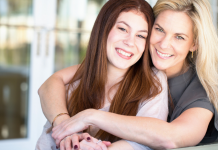 Mom and teen daughter, Mom is embracing daughter and both are smiling.