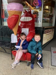 kids sitting on lobster eating ice cream statue
