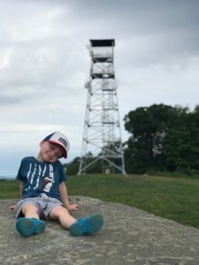 boy sits in front of firetower